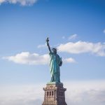 Statue of Liberty, New York under white and blue cloudy skies