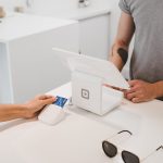 person using white tablet computer on table