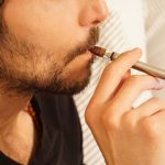 man in black shirt smoking cigarette