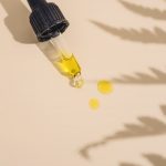 a dropper bottle filled with yellow liquid sitting on top of a table