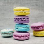 four macarons balancing near two and one macarons