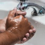 person washing hand on sink