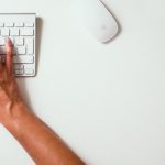 person typing on Apple Cordless Keyboard