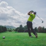 photo of man swinging golf driver