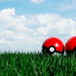 two red and white balls sitting in the grass