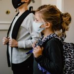 woman in black long sleeve shirt holding white face mask