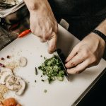 person slicing vegetable