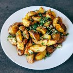 a white plate topped with potatoes and parsley