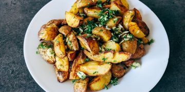 a white plate topped with potatoes and parsley