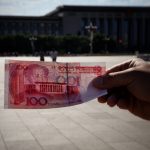 a person holding a piece of paper with a picture of a building in the background