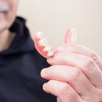 person in black hoodie holding white candy