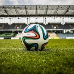 Multicolored Soccer Ball on Green Field