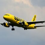 a yellow and black airplane flying