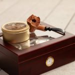 tobacco pipe and herb grinder on brown box