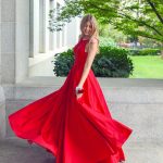 woman in red sleeveless dress standing on gray concrete floor during daytime