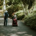 a man and a woman walking down a dirt road