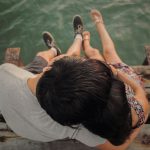 man and woman hugging each other on brown wooden dock