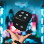 person's left palm about to catch black dice