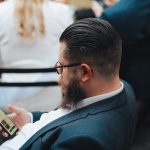 a man sitting in a chair looking at his cell phone