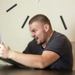 a man sitting in front of a laptop computer