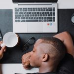 a man sitting at a desk with a laptop and headphones