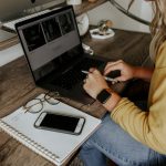 person in blue denim jeans using macbook pro