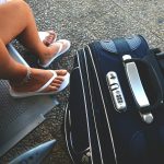 woman sitting on chair beside luggage bag