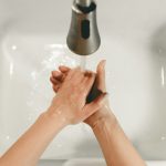 persons feet on white bathtub