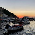 white and red boat on sea during sunset