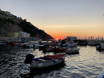 white and red boat on sea during sunset