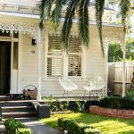 white wooden house with green plants