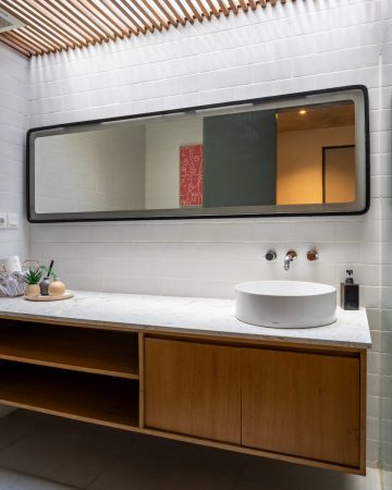 A bathroom with a large mirror and a sink