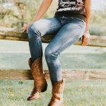 woman sitting on brown wooden fence