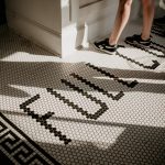 a woman standing on a tiled floor next to a doorway