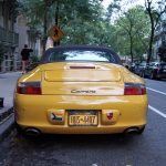 yellow porsche 911 parked on street during daytime