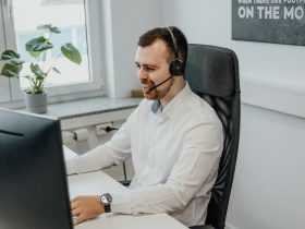 a man wearing a headset sitting in front of a computer