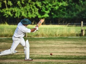 man in white pants and blue baseball mitt holding baseball bat during daytime