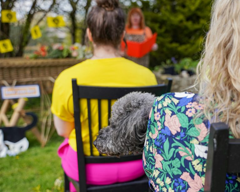 a dog sitting on a chair in front of a woman