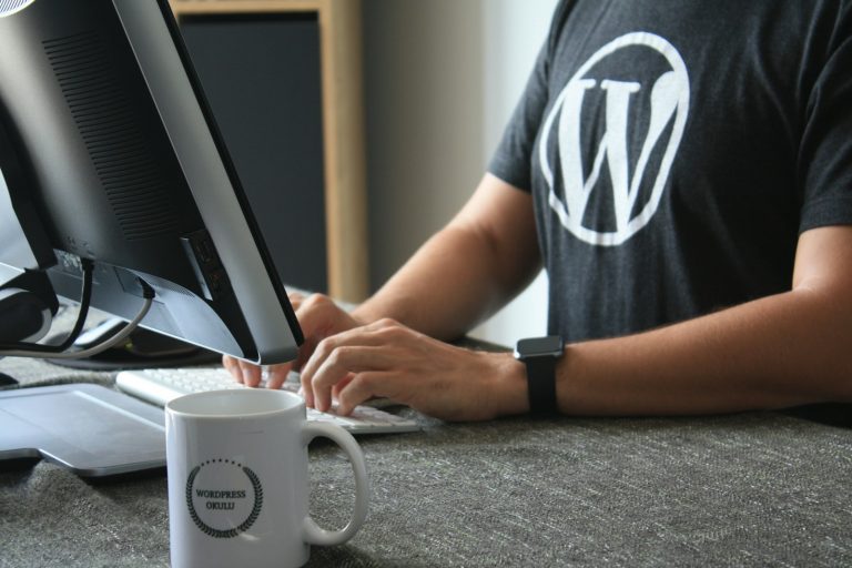 person in black and white t-shirt using computer