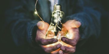 man holding incandescent bulb