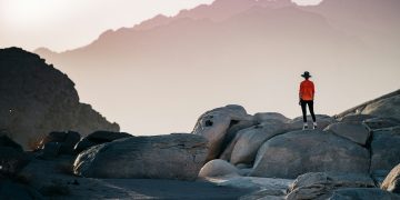 a person standing on top of a large rock