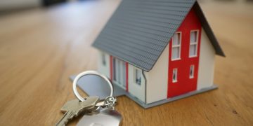 white and red wooden house miniature on brown table