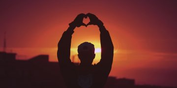 silhouette of man raising his hands