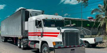 a large semi truck driving down a street