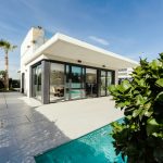 white and grey concrete building near swimming pool under clear sky during daytime