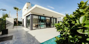 white and grey concrete building near swimming pool under clear sky during daytime