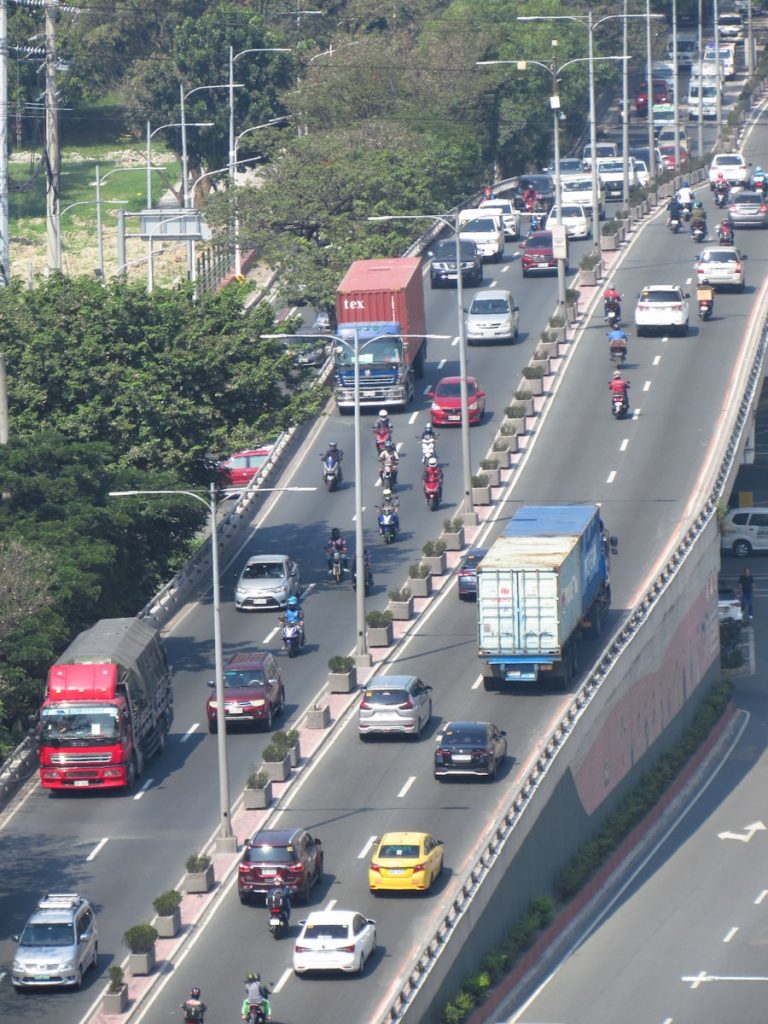 A highway filled with lots of traffic next to trees