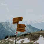 a group of signs on top of a snow covered mountain