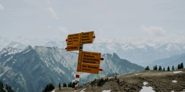 a group of signs on top of a snow covered mountain