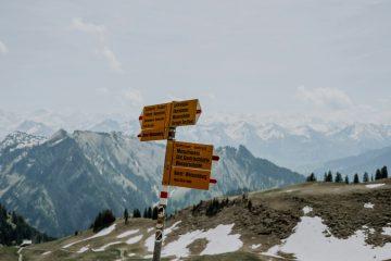 a group of signs on top of a snow covered mountain